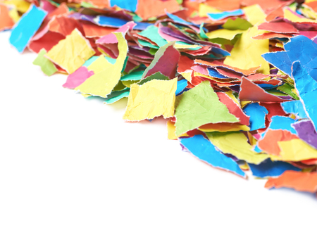 Pile of multiple colorful torn paper pieces isolated over the white background, close-up crop composition with a shallow depth of fieldの写真素材