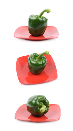 Green bell pepper on a red ceramic plate isolated over the white background, set of three different foreshorteningsの写真素材