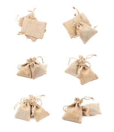 Pile of multiple tiny sackcloth bags with a tie string, composition isolated over the white background, set of six different foreshorteningsの写真素材