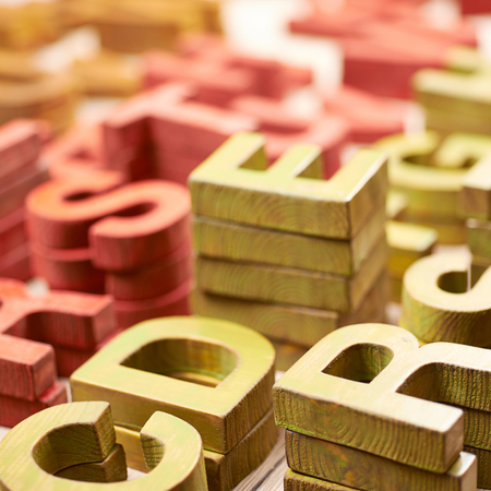 Surface coated with the multiple painted wooden block letters as an abstract backrop compositionの写真素材