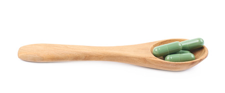 Wooden spoon filled with medical pillsの写真素材