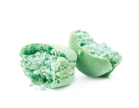 Crumbled bitten macaron cookie isolated over the white backgroundの写真素材