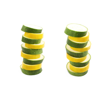 Stack pile of slices of green and yellow zucchini isolated over the white background , set of several different foreshorteningsの写真素材