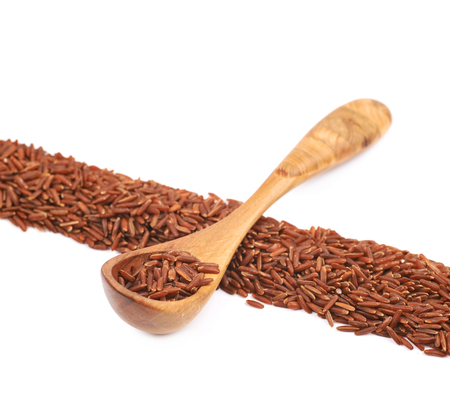 Line made of red rice with the wooden spoon over it, composition isolated over the white backgroundの写真素材