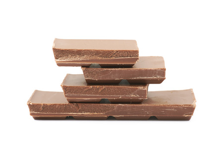 Pile of milk chocolate pieces isolated over the white backgroundの写真素材