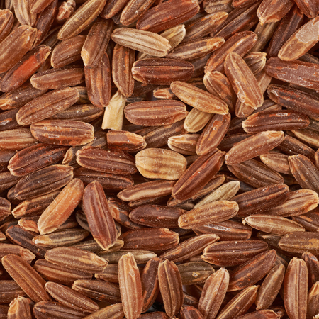 Surface coated with the brown rice grains as a food and cooking backdrop compositionの写真素材