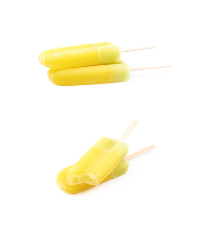 Frozen juice yellow popsicle isolated over the white background, set of two different foreshorteningsの写真素材