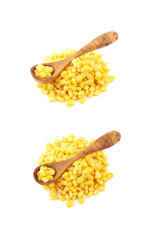Pile of canned corn with the wooden spoon over it, composition isolated over the white background, set of two different compositionsの写真素材