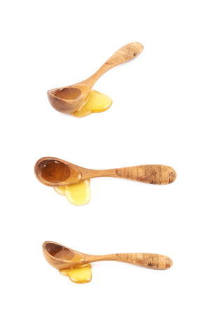 Puddle of honey with the wooden spoon over it, composition isolated over the white background, set of three different compositionsの写真素材