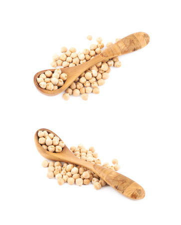Pile of chick peas with the wooden spoon over it, composition isolated over the white background, set of two different foreshorteningsの写真素材