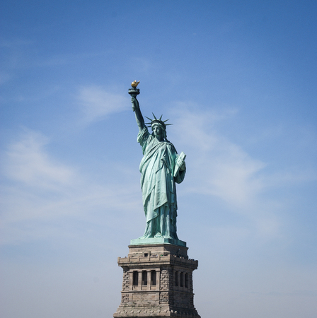 Liberty Statue with a blue sky in the background with a bit cloudsの写真素材