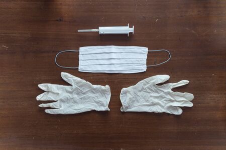Two gloves with a mask and a syringe