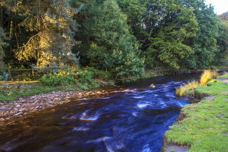 River flowing in between autumn trees at Langsett Reservoir, South Yorkshireの写真素材