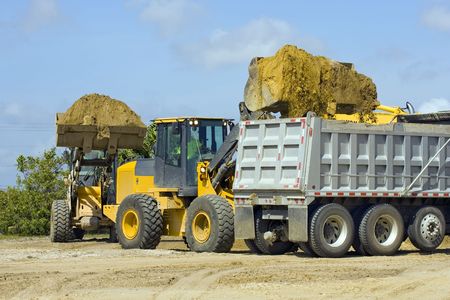 Front end loaders team up to fill a dump truck