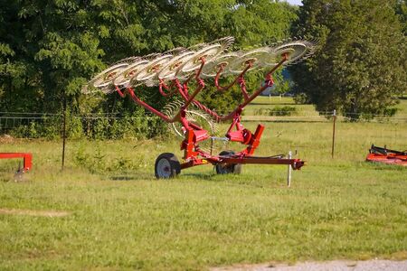 A new hay rake for sale on an agricultual sales lot