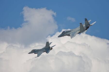 A pair of fighters fly past wingtip to wingtipの写真素材