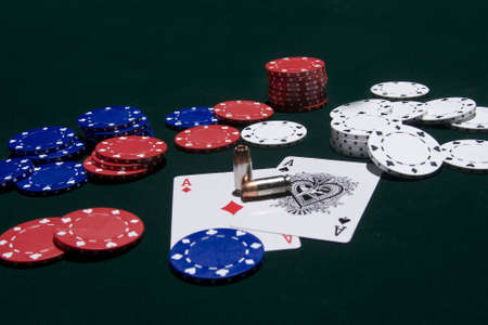 A pair of aces and a pair of bullets with poker chips.のeditorial素材