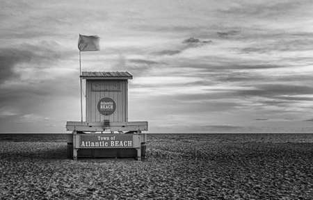 The beach in front of the area locally known as "the circle" at Atlantic Beach, North Carolina. This is the public beach area.. Several taverns, restuarants and gift shops are found in this vicinity.. Pictured is the main lifeguard stand, one of three along this strand. This image was made slightly after sunset on a mid-September evening. Between Memorial Day and Labor Day this section of beach would likely be swarming with tourists and locals enjoying the view and sounds of the ocean.の写真素材