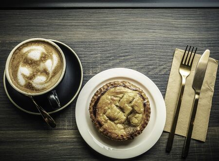 Top view Cup of hot espresso coffee and a apple pie on wood counter.