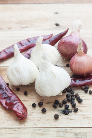 thai seasoning raw ingredient garlic red chill pepper and onion on woodの写真素材