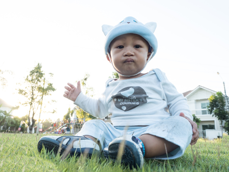 baby sitting on the grass green gardenの写真素材