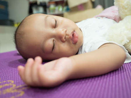 Portrait of a baby lying in bed at homeの写真素材