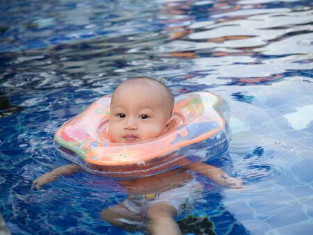 little boy in the swimming pool in hot dayの写真素材