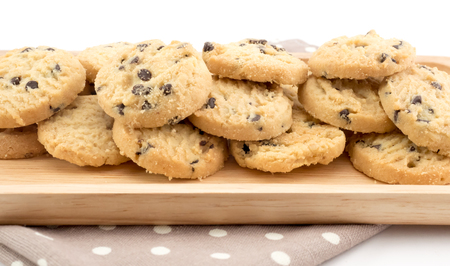 Chocolate chip cookies on white background and wood dishの写真素材