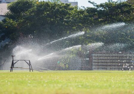 Sprinkler watering the grass of the football fieldの写真素材