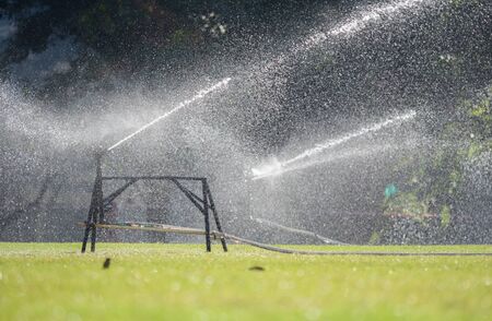 Sprinkler watering the grass of the football fieldの写真素材