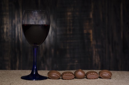 wine in a glass glass on a sacking with chocolateの写真素材