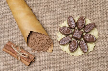 candies in chocolate with cocoa powder against a sackingの写真素材