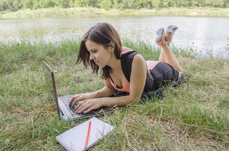 a girl works at the computer on natureの写真素材