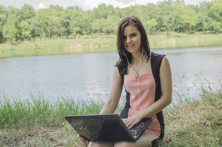 a girl works at the computer on natureの写真素材