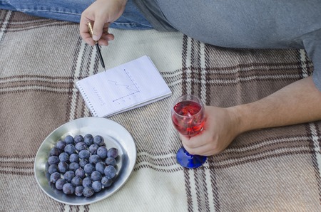 the young guy writes in a notebook in the open airの写真素材