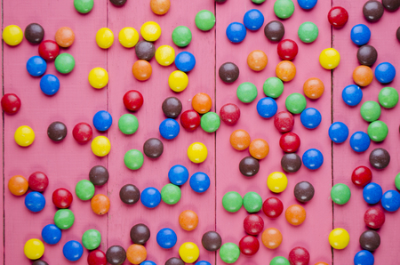 bright candies on a wooden pink tableの写真素材