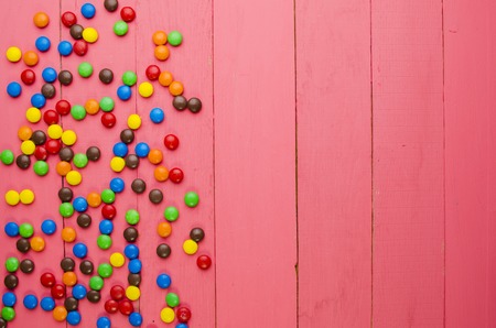 bright candies on a wooden pink tableの写真素材