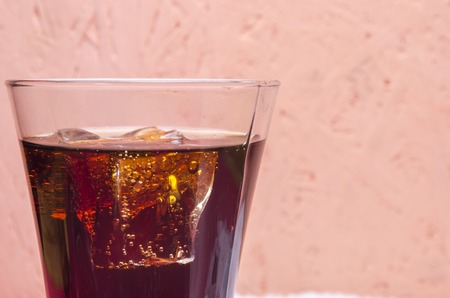 sweet soda in a glass with ice on a tableの写真素材