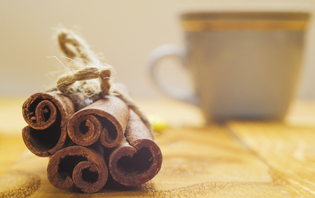 cinnamon close up on a table with a cup of coffeeの写真素材