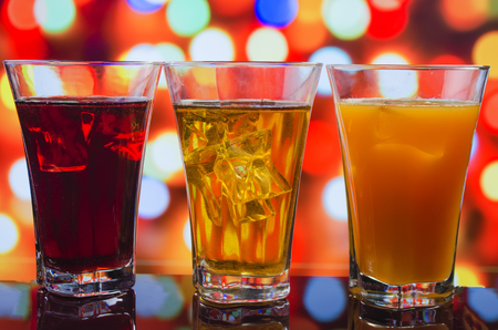 the refreshing juice with ice on a bright multi-colored backgroundの写真素材
