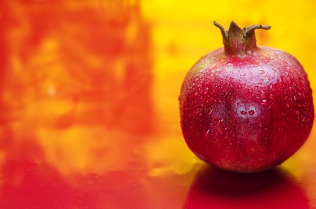 red and fresh pomegranate on a red backgroundの写真素材
