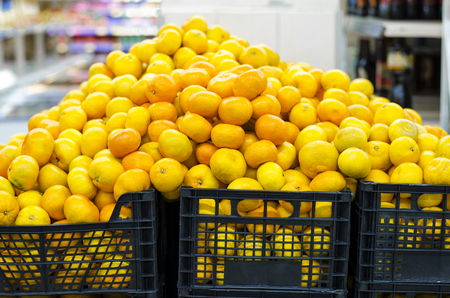 pile of fresh mandarin oranges in a supermarketの写真素材