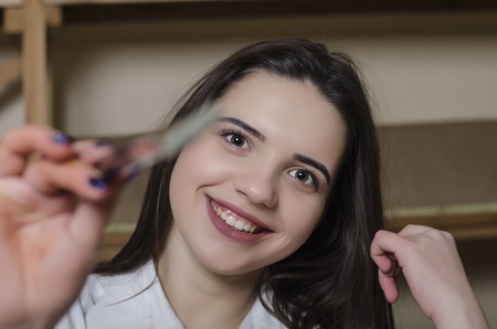 young woman with a brush draws on screenの写真素材