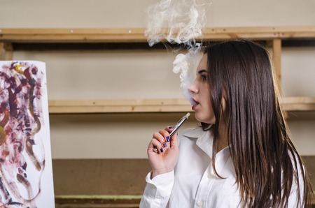 she let the smoke out of his mouth at the art studioの写真素材