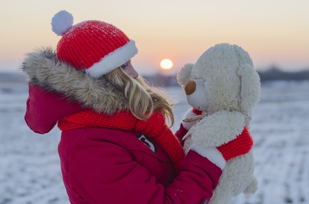 girl holding a bear and goes to sundownの写真素材