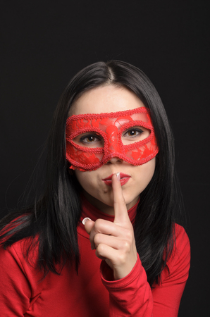 Young girl in a carnival mask on a black backgroundの写真素材