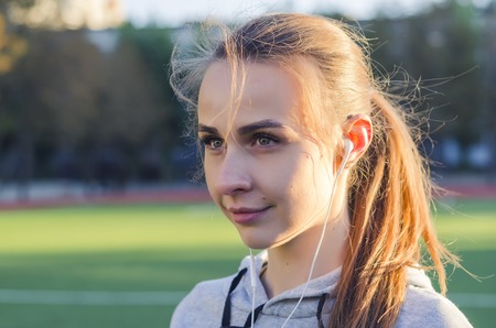 portrait of a girl with headphones outdoors in the morning