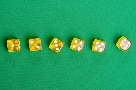 yellow game dice for board game on a green background