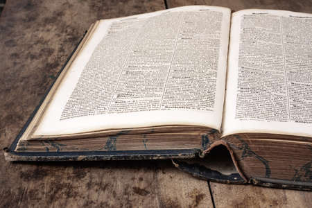 Old book lies on a wooden background