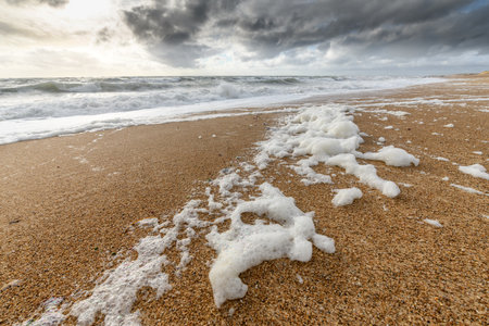 Windswept sea foam on a beach in the Atlantic Ocean near Olonne sur mer in Franceの写真素材